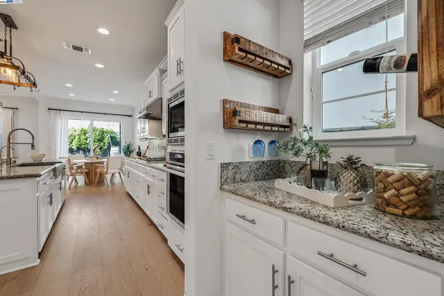 a large kitchen with kitchen island a large counter space a sink stainless steel appliances and cabinets