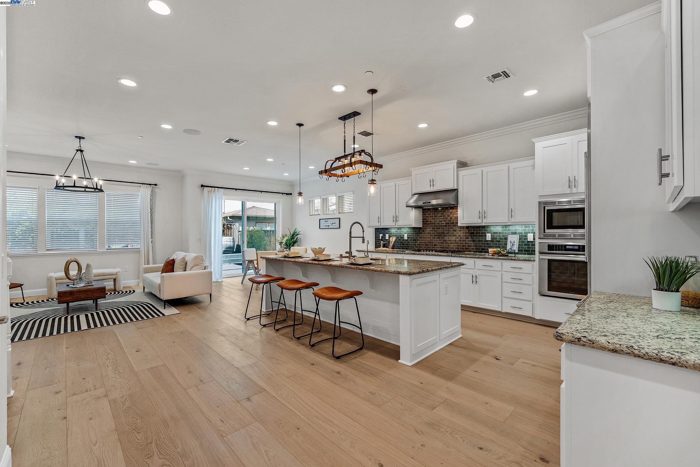 4519 Spring Mountain Way Dublin, CA 94568 - Photo 10 of 52 a large kitchen with kitchen island a large counter space a sink stainless steel appliances and cabinets