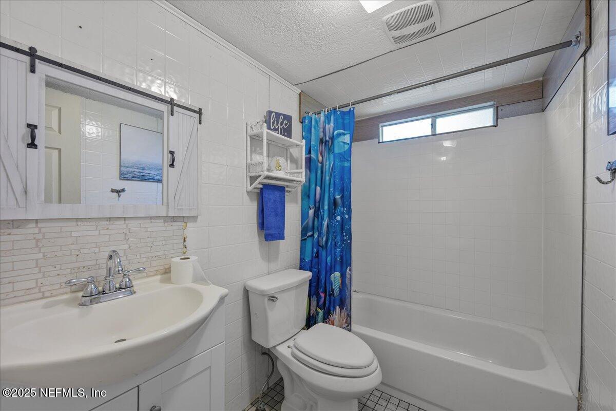 4961 Bent Twig Road Middleburg, FL 32068 - Photo 13 of 17 a bathroom with a sink toilet and shower