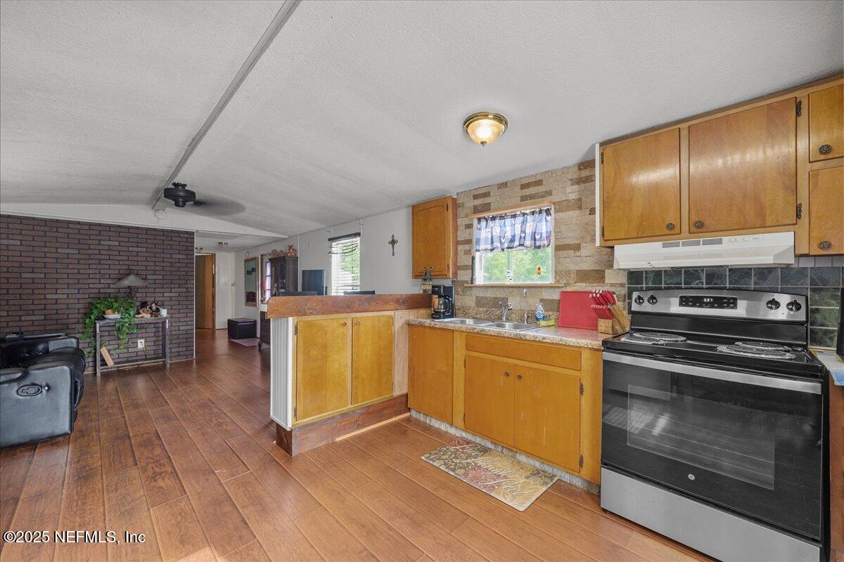 4961 Bent Twig Road Middleburg, FL 32068 - Photo 6 of 17 a kitchen with stainless steel appliances a stove a sink cabinets and a wooden floor