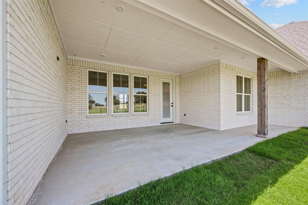 2705 Gospel Road Tolar, TX 76476 - Photo 27 of 36 Expansive covered patio featuring a concrete slab, exposed wood support column, recessed lighting, and white brick exterior