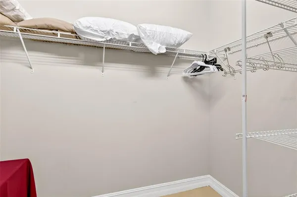 a view of walk in closet with clothes and shoes