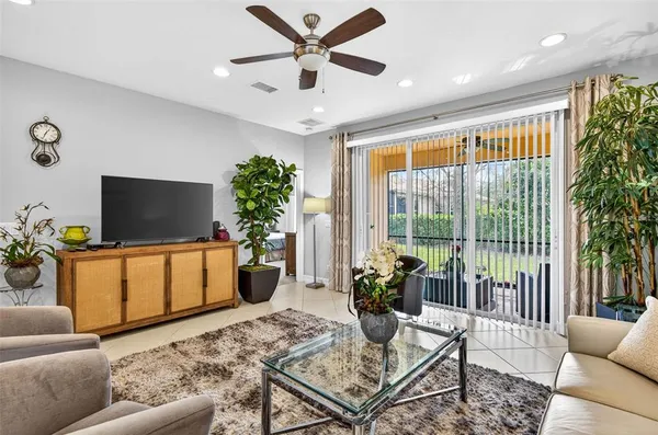 a living room with furniture a flat screen tv and a large window
