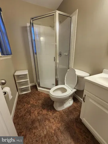 a white toilet sitting next to a bathroom sink and a shower