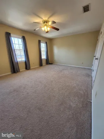 a view of an empty room with chandelier and fireplace