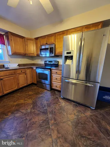 a kitchen with stainless steel appliances granite countertop a refrigerator a stove top oven a sink and dishwasher