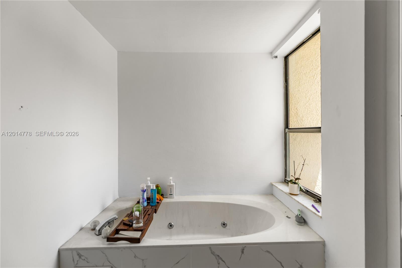5850 Camino Del Sol, Unit 404 Boca Raton, FL 33433 - Photo 25 of 47 a bathroom with a bathtub and a window