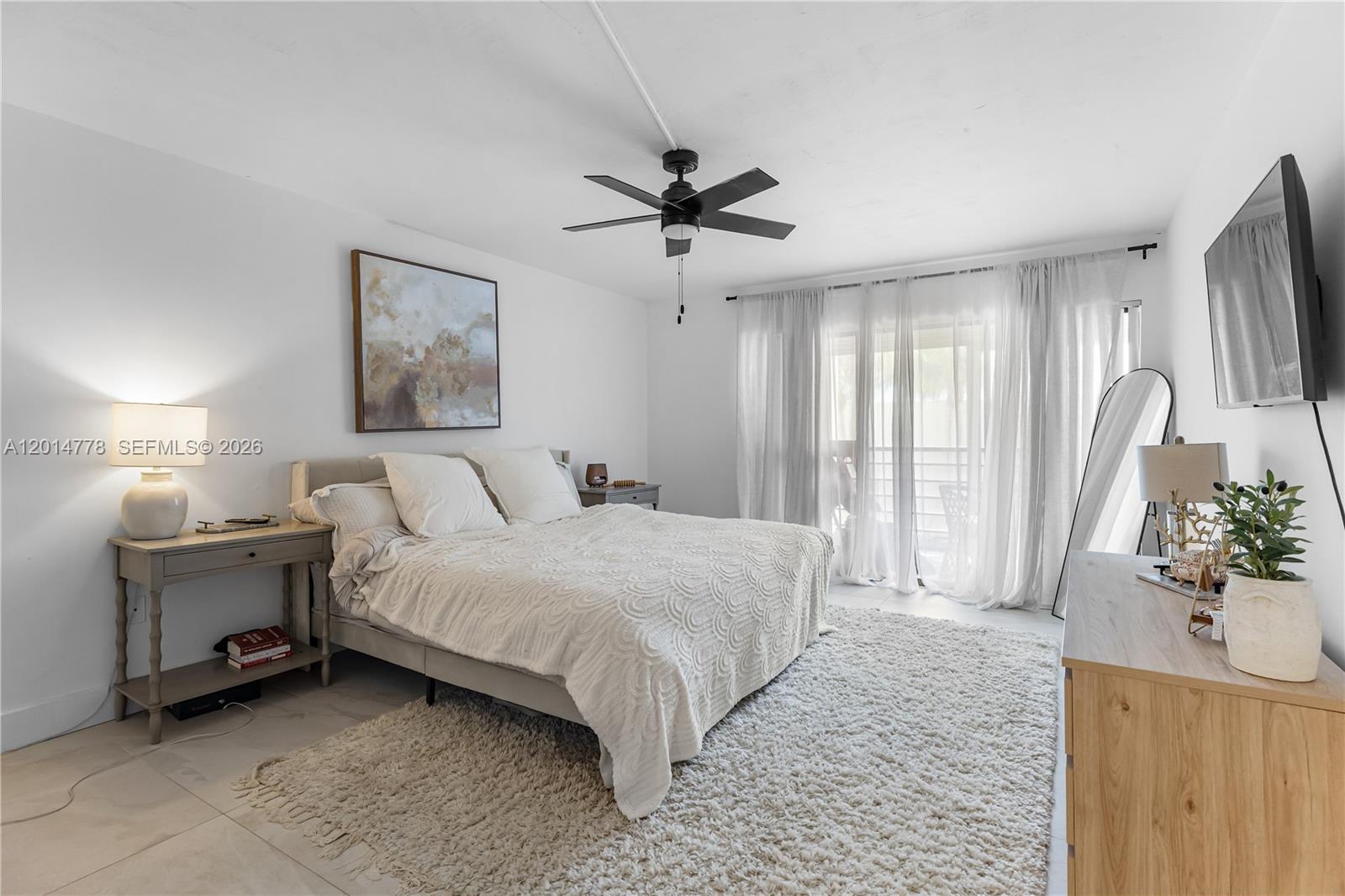 5850 Camino Del Sol, Unit 404 Boca Raton, FL 33433 - Photo 27 of 47 a spacious bedroom with a large bed and a chandelier