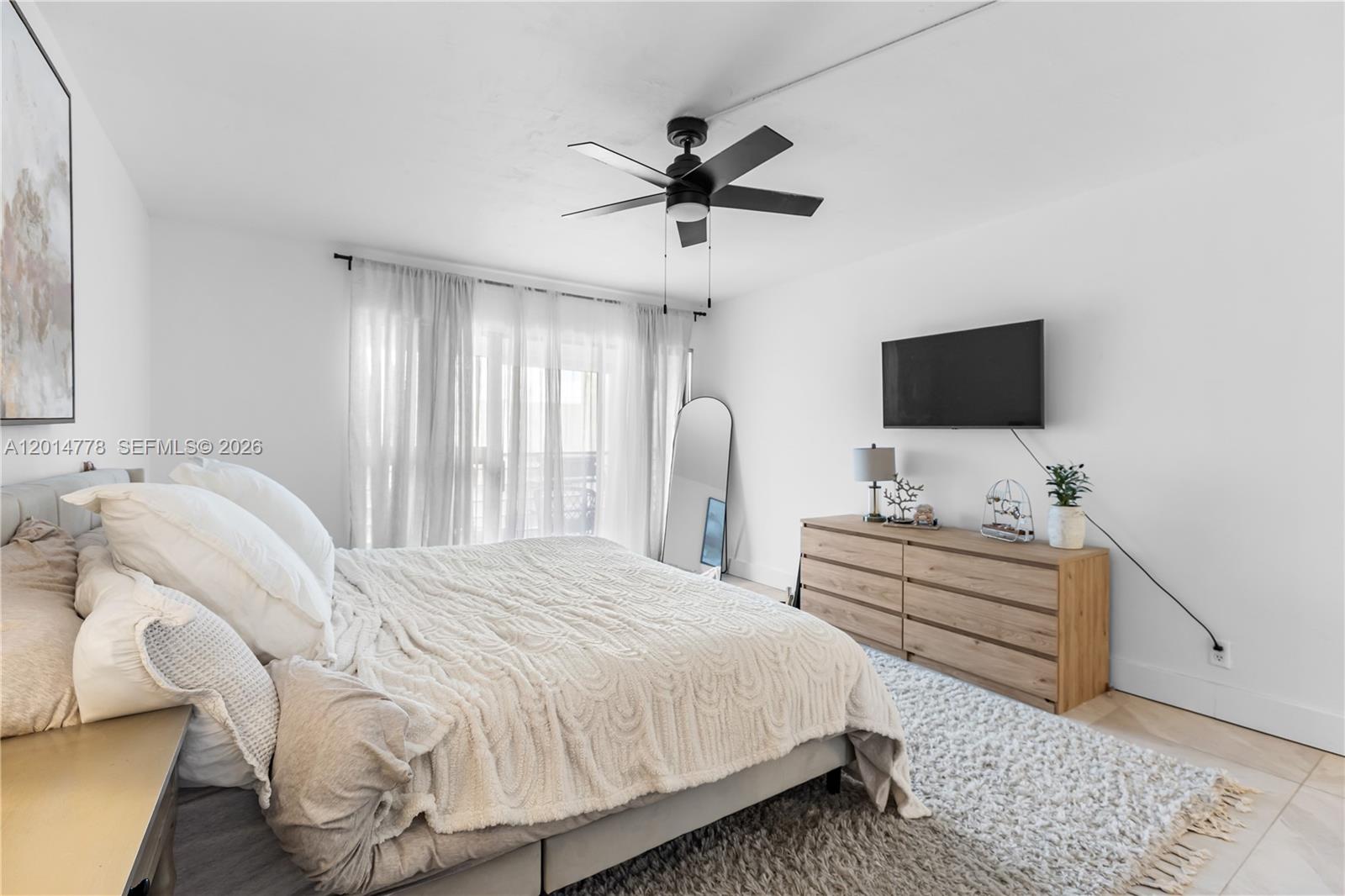 5850 Camino Del Sol, Unit 404 Boca Raton, FL 33433 - Photo 29 of 47 a bedroom with a bed and a flat screen tv