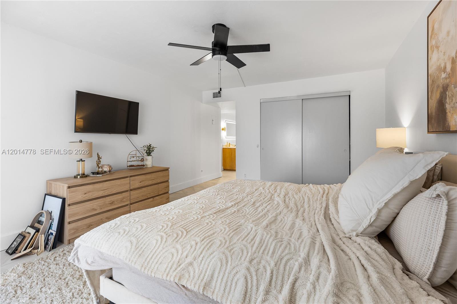 5850 Camino Del Sol, Unit 404 Boca Raton, FL 33433 - Photo 32 of 47 a bedroom with a bed and a flat screen tv
