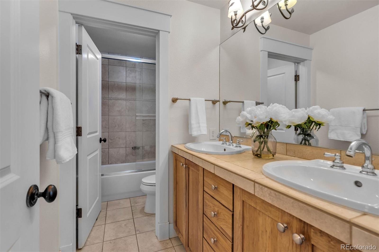 4755 Highline Place Denver, CO 80222 - Photo 31 of 40 a bathroom with a double vanity sink toilet mirror and shower