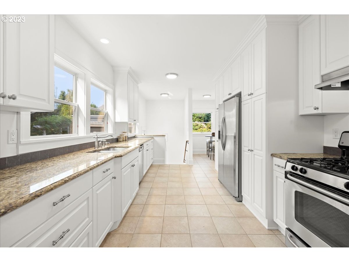 2015 Northeast 38th Avenue Portland, OR 97212 - Photo 13 of 32 a large white kitchen with stainless steel appliances granite countertop a stove a sink a refrigerator and cabinets