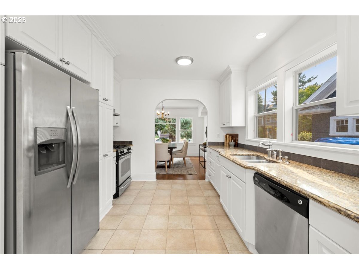 2015 Northeast 38th Avenue Portland, OR 97212 - Photo 16 of 32 a large kitchen with stainless steel appliances granite countertop a refrigerator a sink dishwasher a stove and white countertops with wooden floor