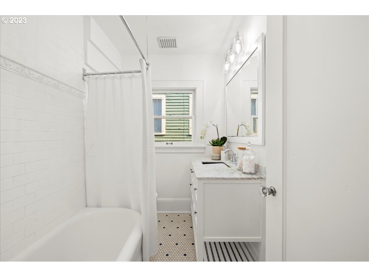 2015 Northeast 38th Avenue Portland, OR 97212 - Photo 21 of 32 a bathroom with a sink a mirror and a bathtub