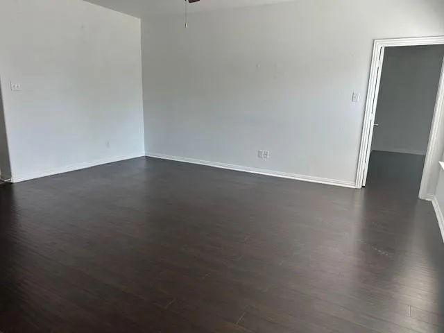 an empty room with wooden floor and white walls