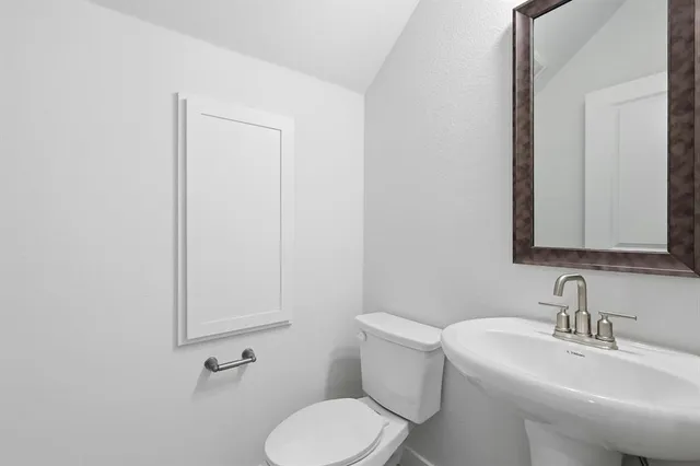 a white toilet sitting next to a bathroom sink