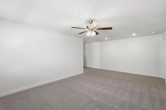 an empty room with a window and a ceiling fan