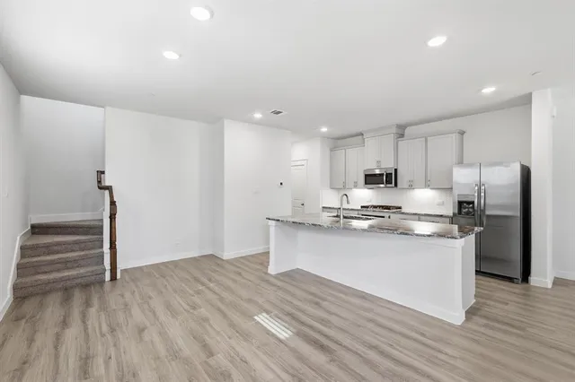 a kitchen with stainless steel appliances granite countertop a stove and a refrigerator