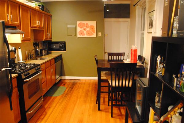 a kitchen with stainless steel appliances granite countertop a table chairs and a refrigerator