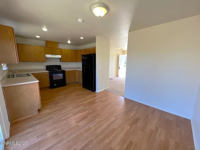 a view of a kitchen with a sink and a refrigerator