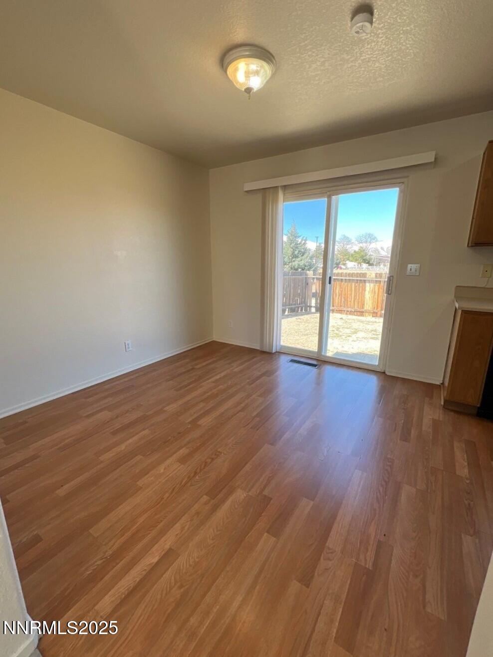 13405 Mt Lassen Street Reno, NV 89506 - Photo 6 of 20 an empty room with wooden floor and windows