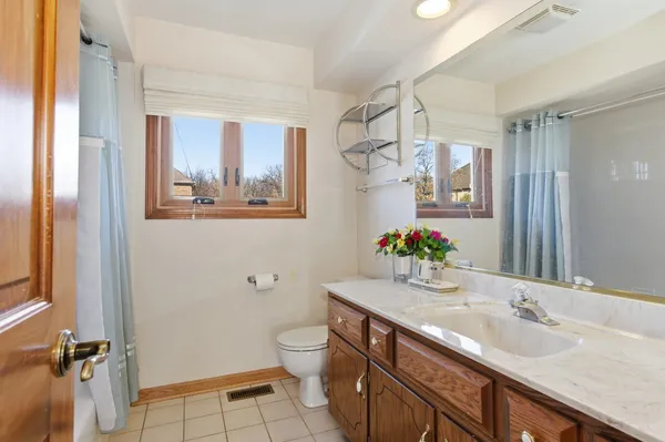 a bathroom with a granite countertop sink mirror vanity and toilet