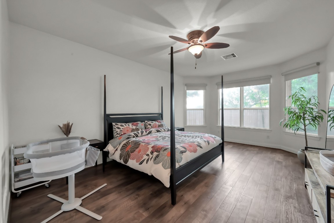 22202 Weller Oaks Drive Spring, TX 77389 - Photo 17 of 39 a bedroom with a bed and a chandelier