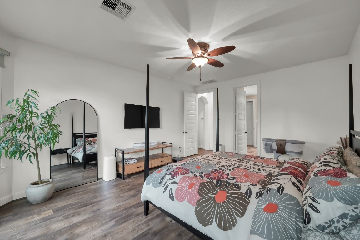 22202 Weller Oaks Drive Spring, TX 77389 - Photo 18 of 39 a bedroom with a bed and a chandelier