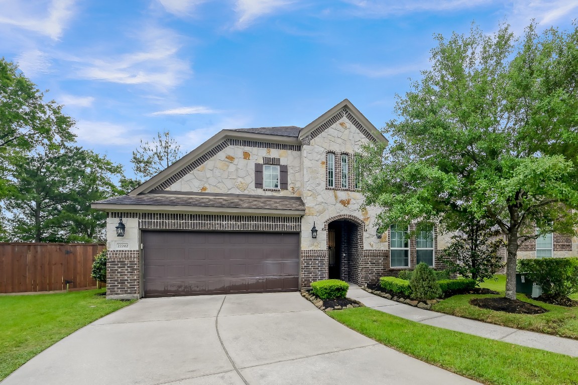 22202 Weller Oaks Drive Spring, TX 77389 - Photo 2 of 39 a front view of a house with a garden and trees