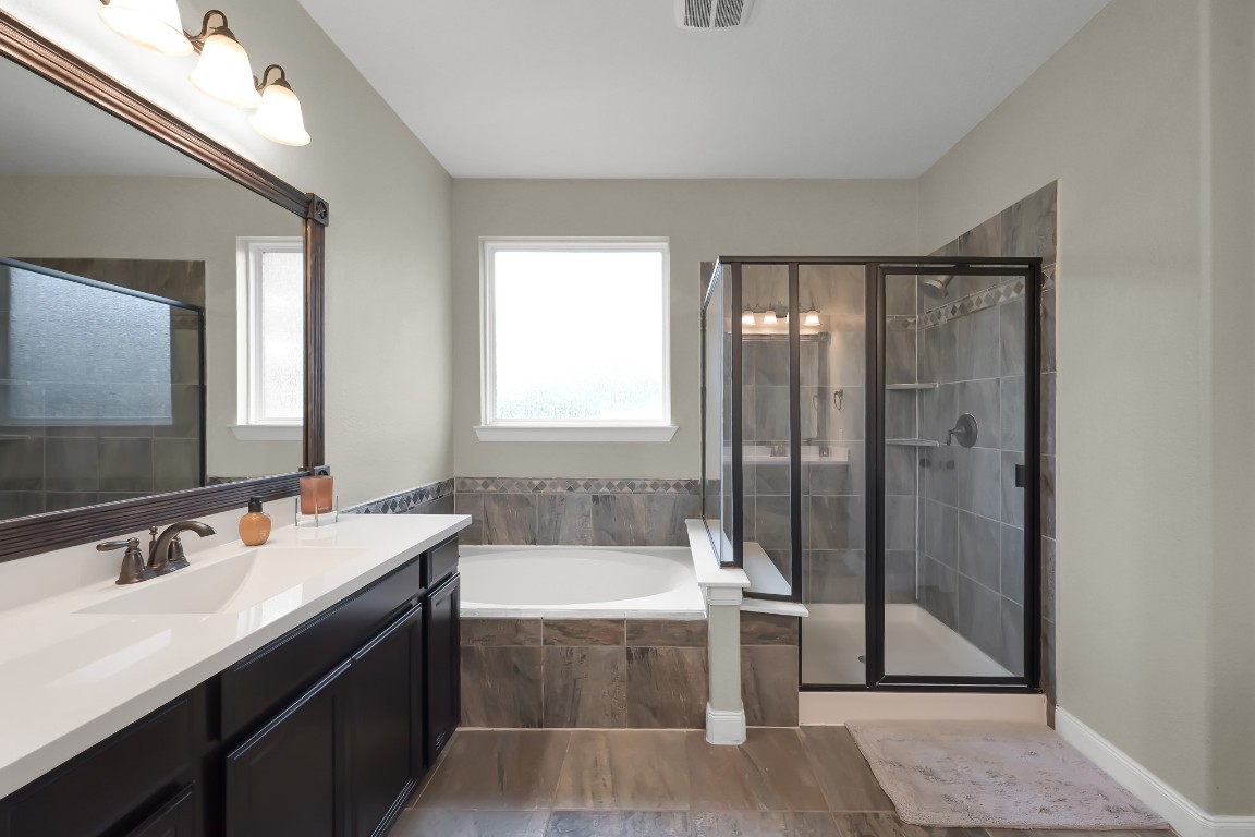 22202 Weller Oaks Drive Spring, TX 77389 - Photo 21 of 39 a bathroom with a tub a sink and mirror