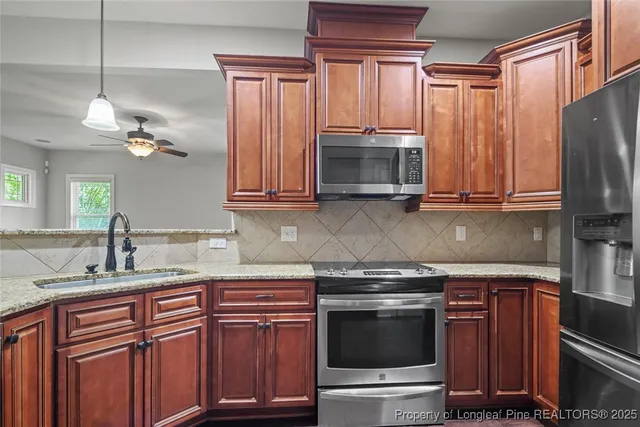 a kitchen with stainless steel appliances granite countertop a sink stove and microwave
