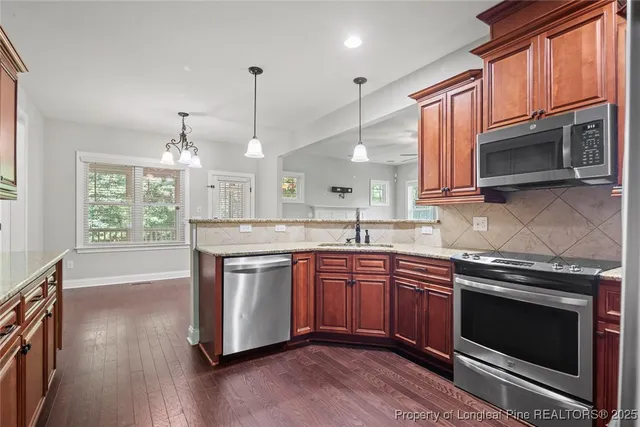 a kitchen with stainless steel appliances granite countertop a stove a sink and a microwave