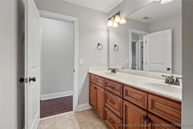 a spacious bathroom with double vanity and a mirror