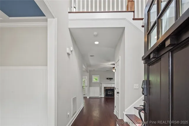 a view of a hallway with wooden floor and staircase