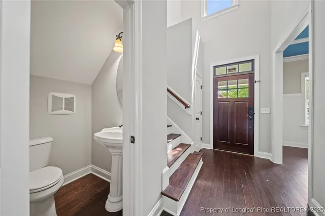 a view of a hallway with wooden floor and staircase
