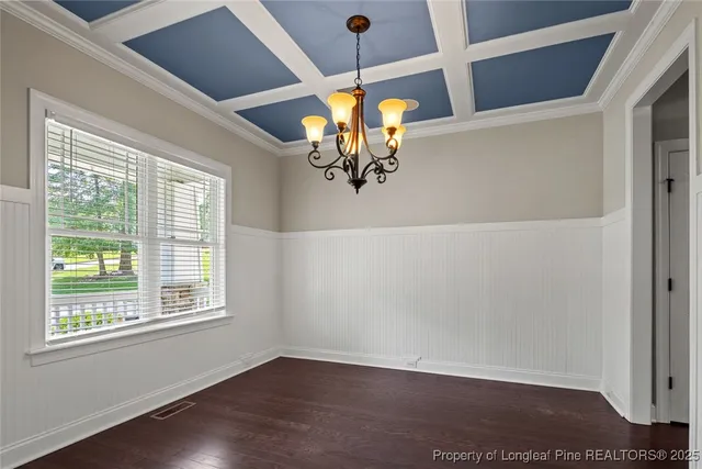 a view of a dining room with wooden floor and chandelier