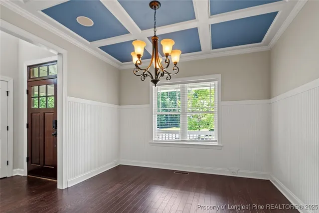 a view of a room with wooden floor chandelier and a window