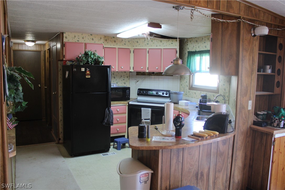 5470 Rainbow Drive Bokeelia, FL 33922 - Photo 11 of 21 a kitchen with stainless steel appliances granite countertop a refrigerator a stove and a sink