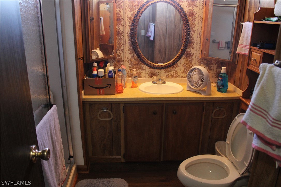 5470 Rainbow Drive Bokeelia, FL 33922 - Photo 13 of 21 a bathroom with a toilet mirror vanity and a sink