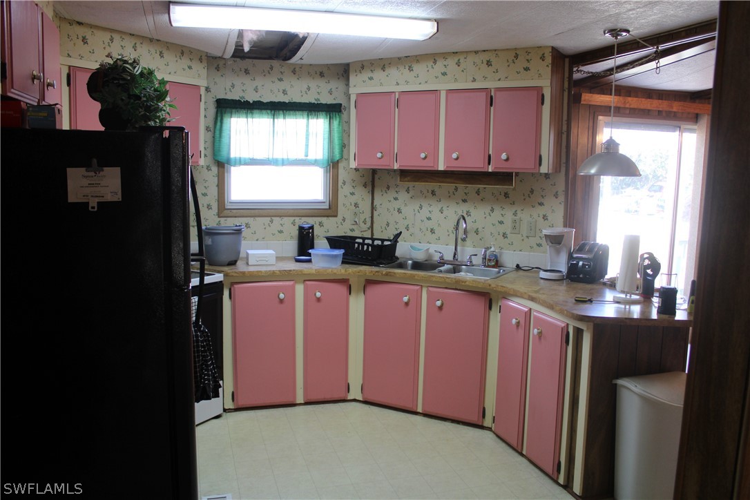 5470 Rainbow Drive Bokeelia, FL 33922 - Photo 10 of 21 a kitchen with granite countertop a sink stove top oven and cabinets
