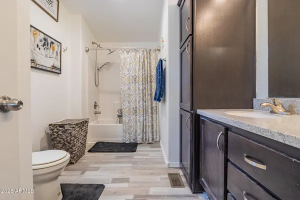 a bathroom with a granite countertop sink toilet and shower
