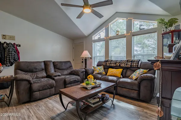 a living room with furniture a flat screen tv and a large window