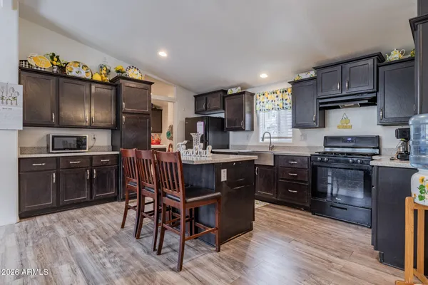 a kitchen with stainless steel appliances kitchen island granite countertop a refrigerator stove top oven and sink