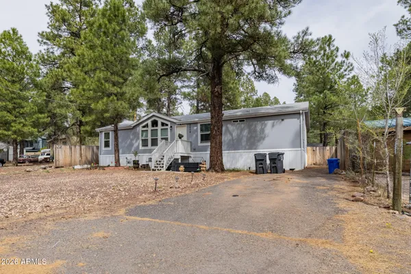 a view of a house with a large space and a large tree