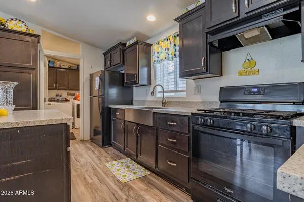 a kitchen with stainless steel appliances granite countertop a stove a sink and a refrigerator