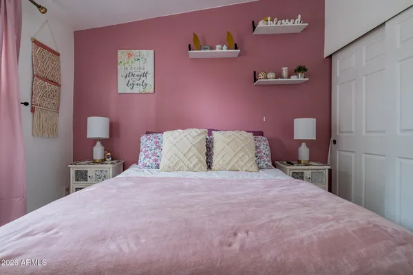 a bedroom with a bed and a painting on the wall
