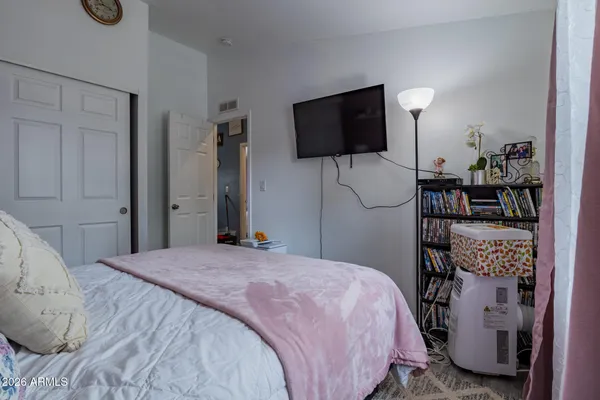 a bedroom with a bed tv and a window