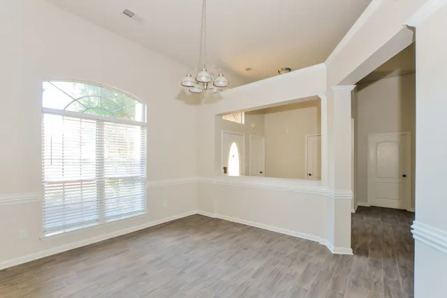 wooden floor in an empty room with a window