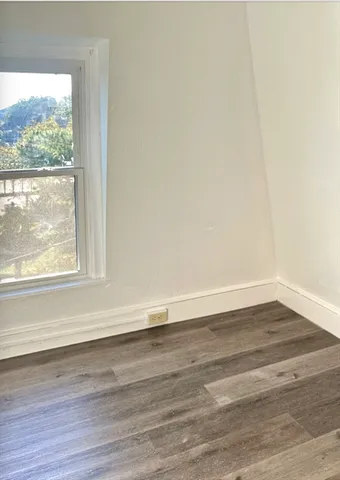 a view of a room with wooden floor and a window