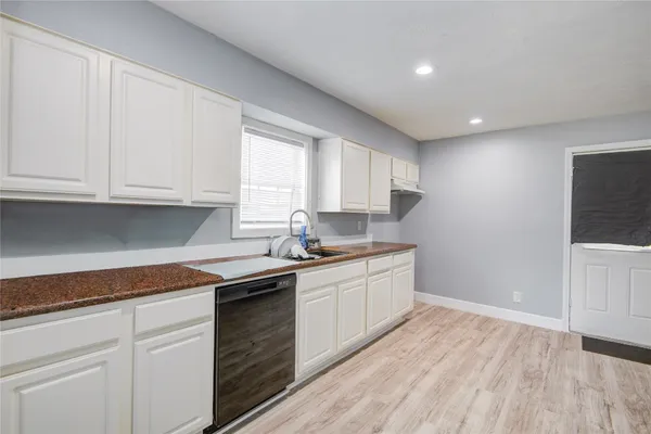 a kitchen with granite countertop white cabinets and white appliances